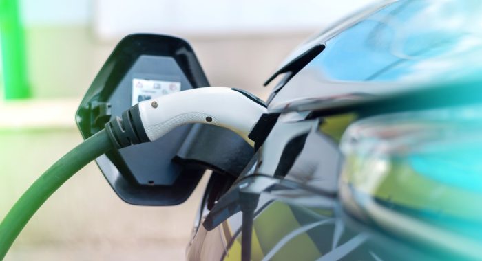 Plugged in charger into an electric car at charge station